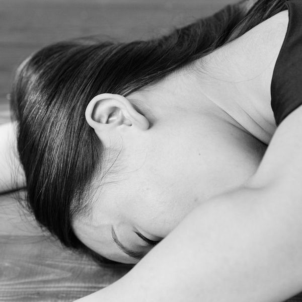 A person rolling out a yoga mat in a calm and welcoming studio.